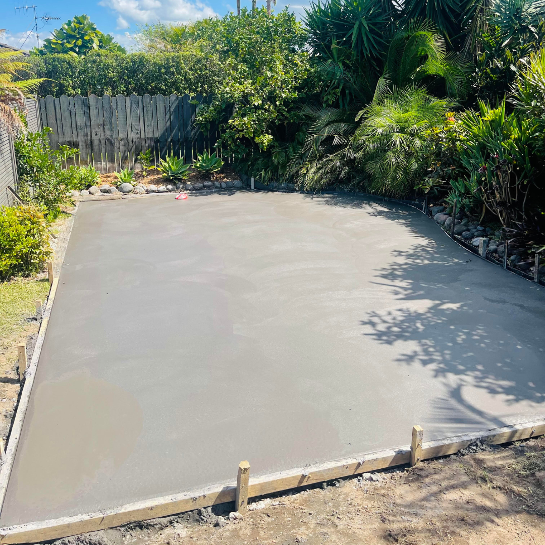 Large freshly poured concrete slab in a fenced Auckland backyard