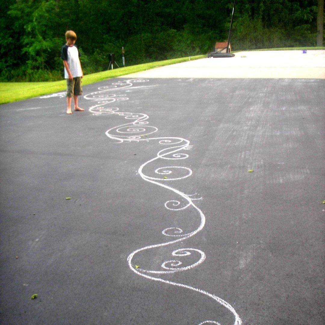 Finished asphalt driveway with a decorative white spiral pattern