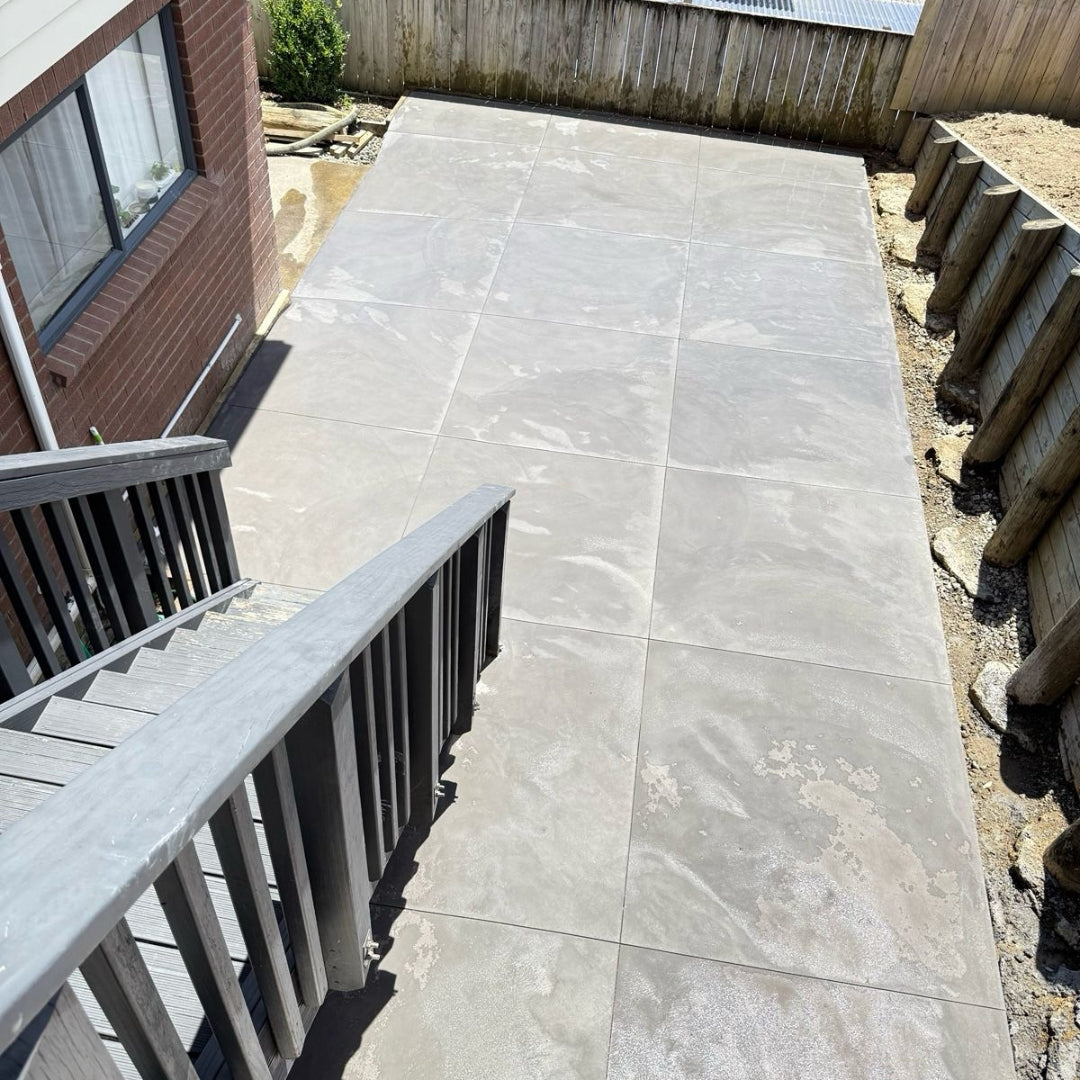 Patterned concrete patio with steps beside a brick Auckland home