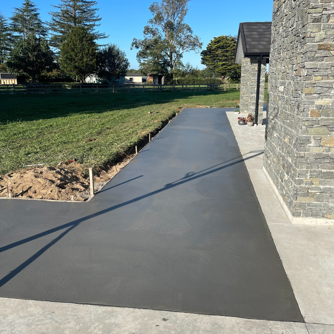Fresh concrete patio beside a stone-clad Auckland home