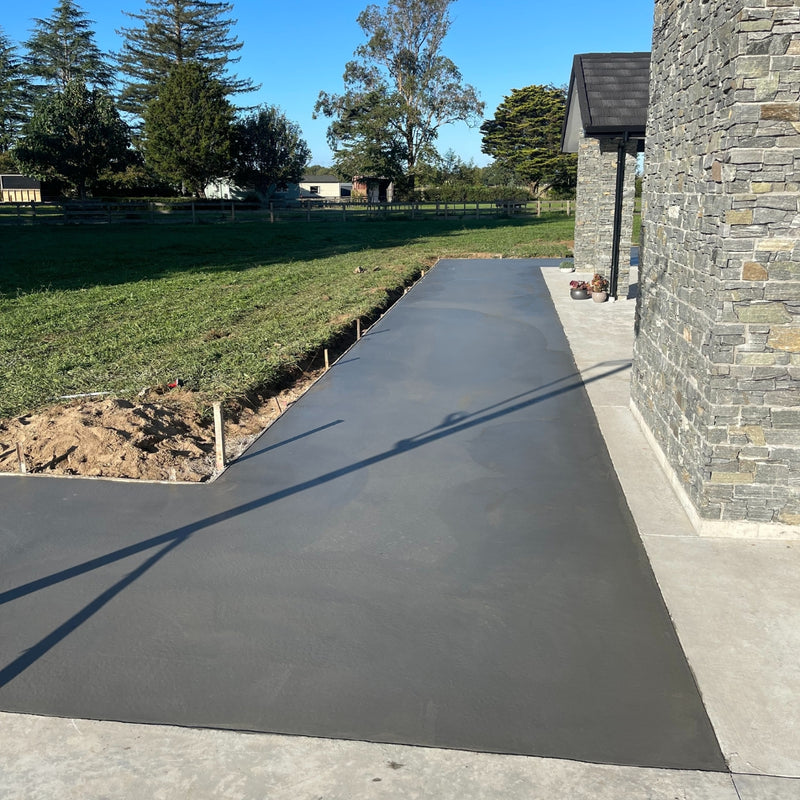 Fresh concrete patio beside a stone-clad Auckland home