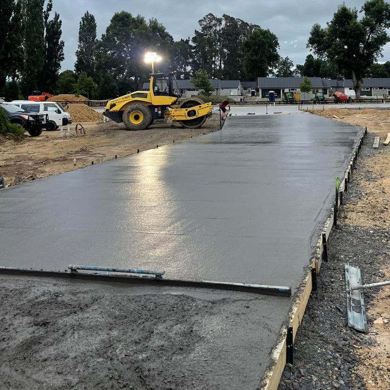 Large freshly floated concrete slab with a compactor and crew on site