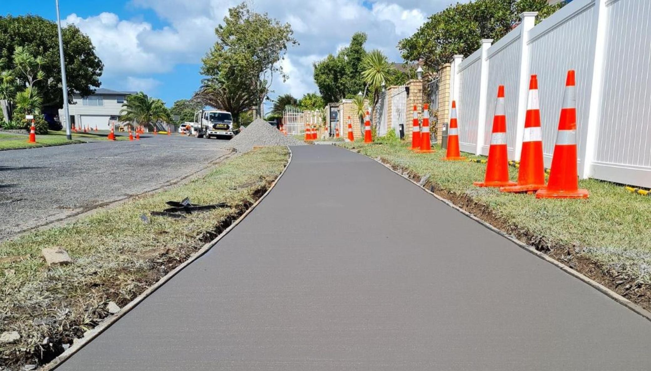 Newly laid footpath beside an Auckland street lined with traffic cones